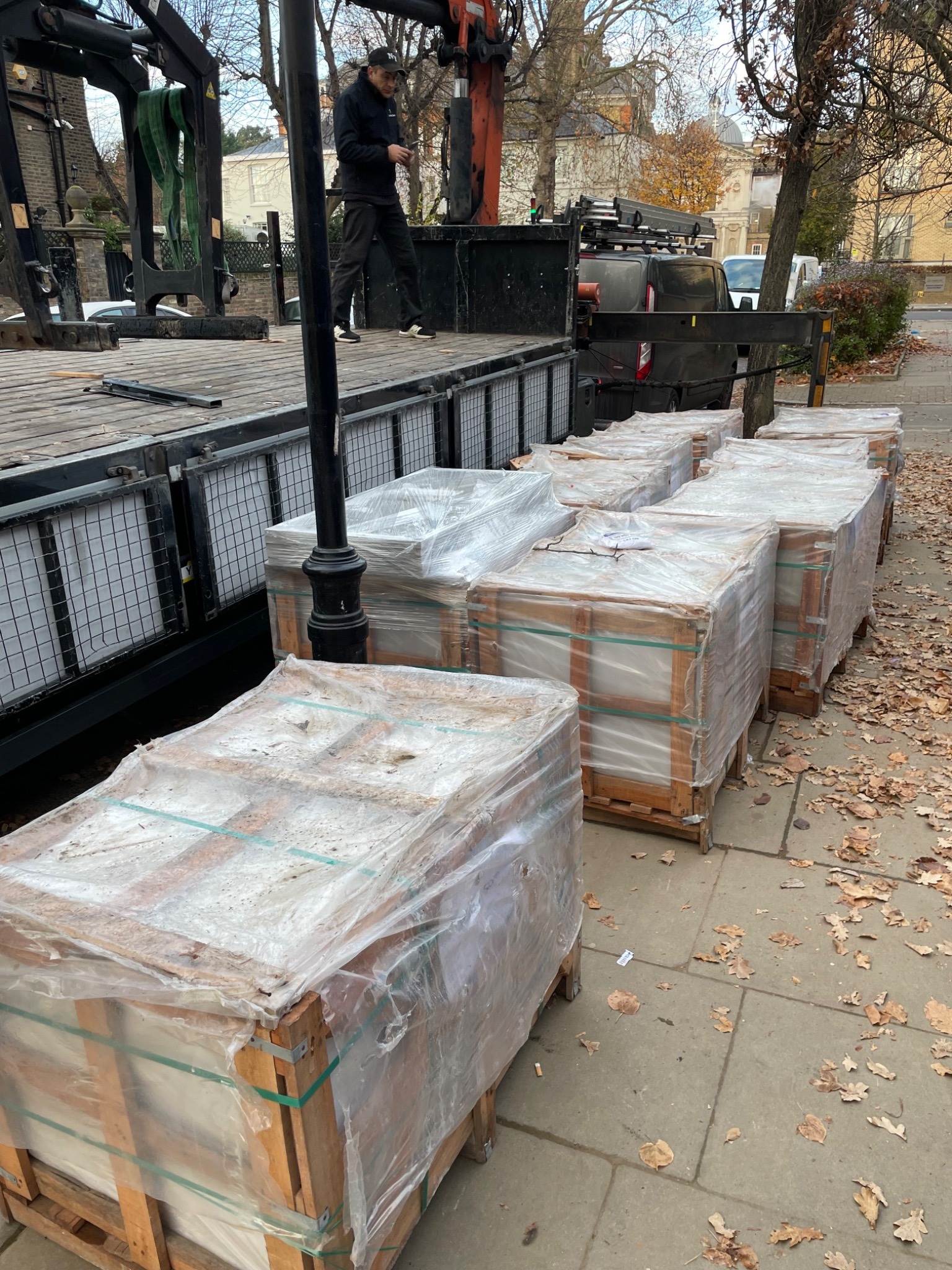 Pallets of garden construction materials being delivered beside a London pavement